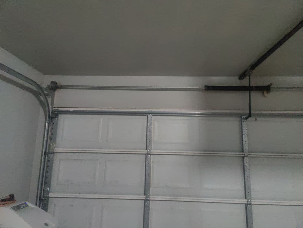 Garage interior featuring a metal track and pipe along the wall near the overhead door.