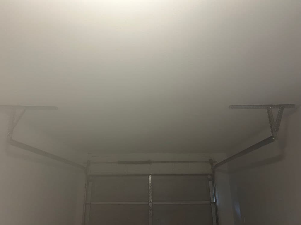 Garage ceiling with metal support brackets installed for overhead storage solutions.