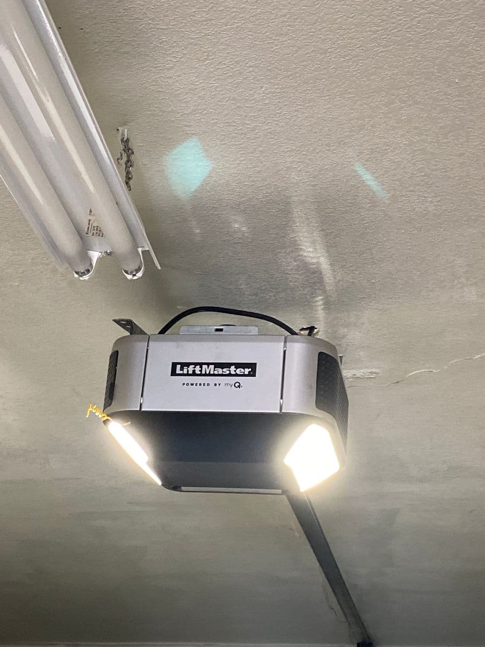 LiftMaster garage door opener with LED lights mounted on ceiling.