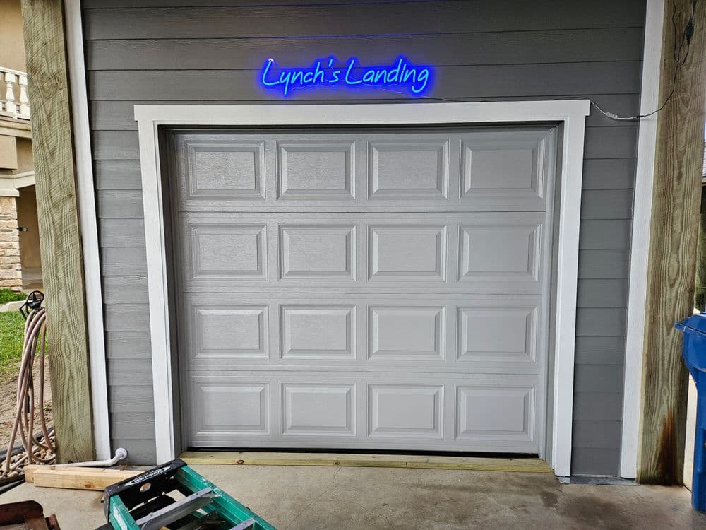Lynch's Landing garage door with blue neon sign above, showcasing modern exterior design.